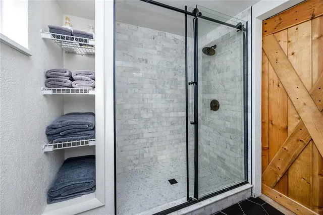 a bathroom with a glass door shower and a sink