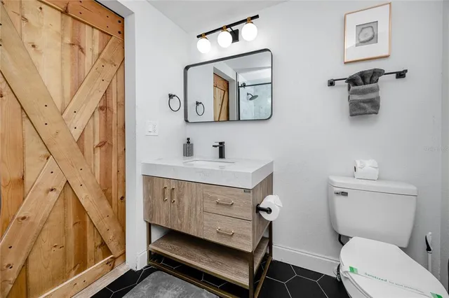 a bathroom with a toilet a sink a mirror and a shower