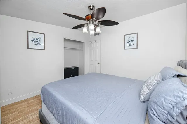 a bedroom with a bed and a ceiling fan