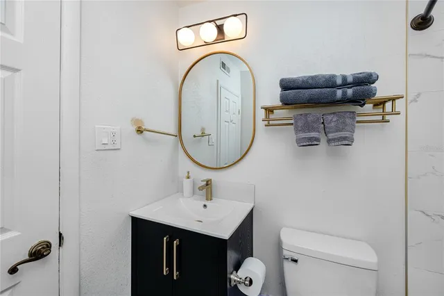 a bathroom with a toilet a sink and a mirror