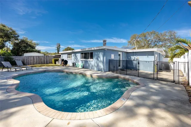 a view of a house with swimming pool and sitting area