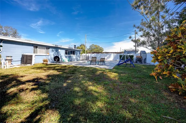 a view of a house with a big yard and large trees