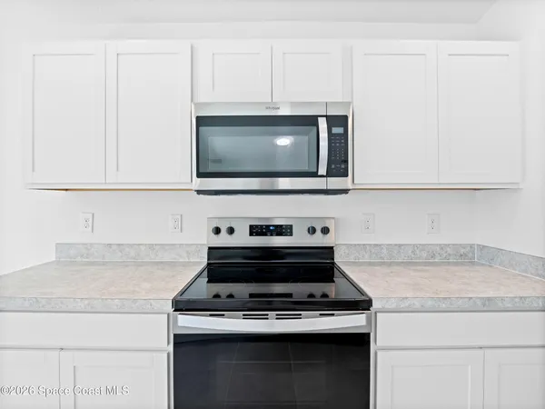 a kitchen with stainless steel appliances granite countertop a refrigerator sink stove microwave and cabinets