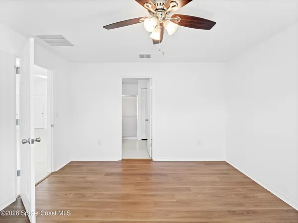 an empty room with a window and a ceiling fan