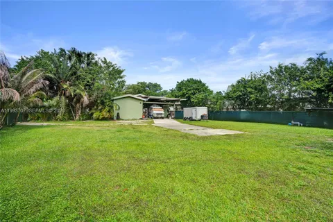 a view of a house with a backyard