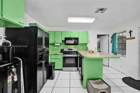 a kitchen with a refrigerator and a stove top oven
