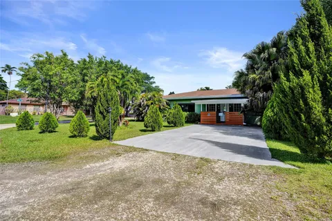 a front view of a house with a yard and trees