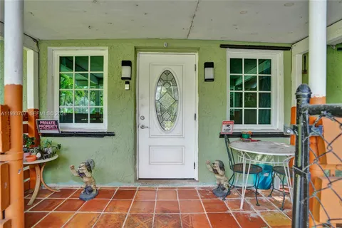 a front view of a house with large windows and a potted plant