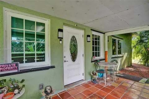a front view of a house with outdoor seating and a potted plant