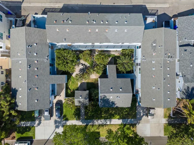 an aerial view of residential houses with outdoor space and parking