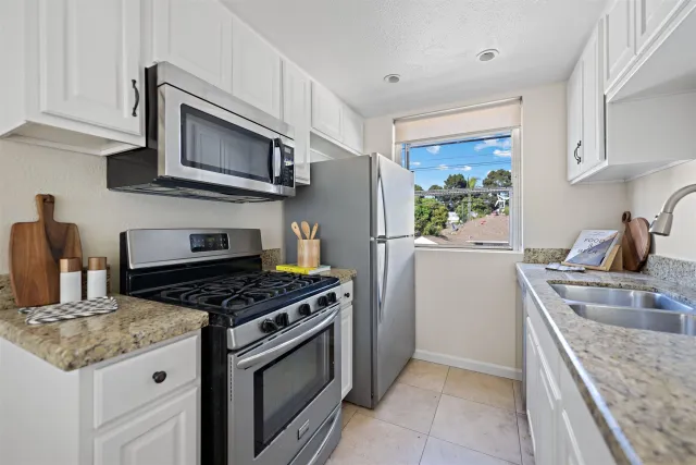 a kitchen with stainless steel appliances granite countertop a sink stove and microwave