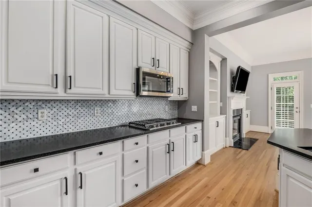 a kitchen with stainless steel appliances granite countertop a sink stove and microwave