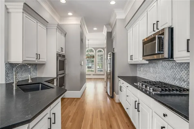 a kitchen with stainless steel appliances granite countertop a sink a stove and a microwave