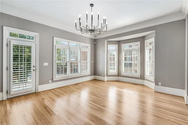 a view of a livingroom with wooden floor a fireplace and windows