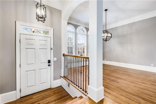 an empty room with wooden floor mirror and balcony