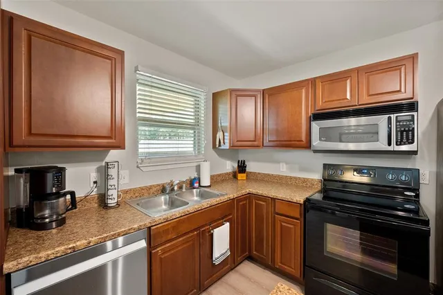 a kitchen with stainless steel appliances granite countertop a sink stove and microwave