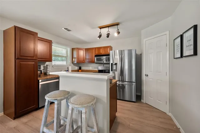 a kitchen with stainless steel appliances a refrigerator stove microwave and sink