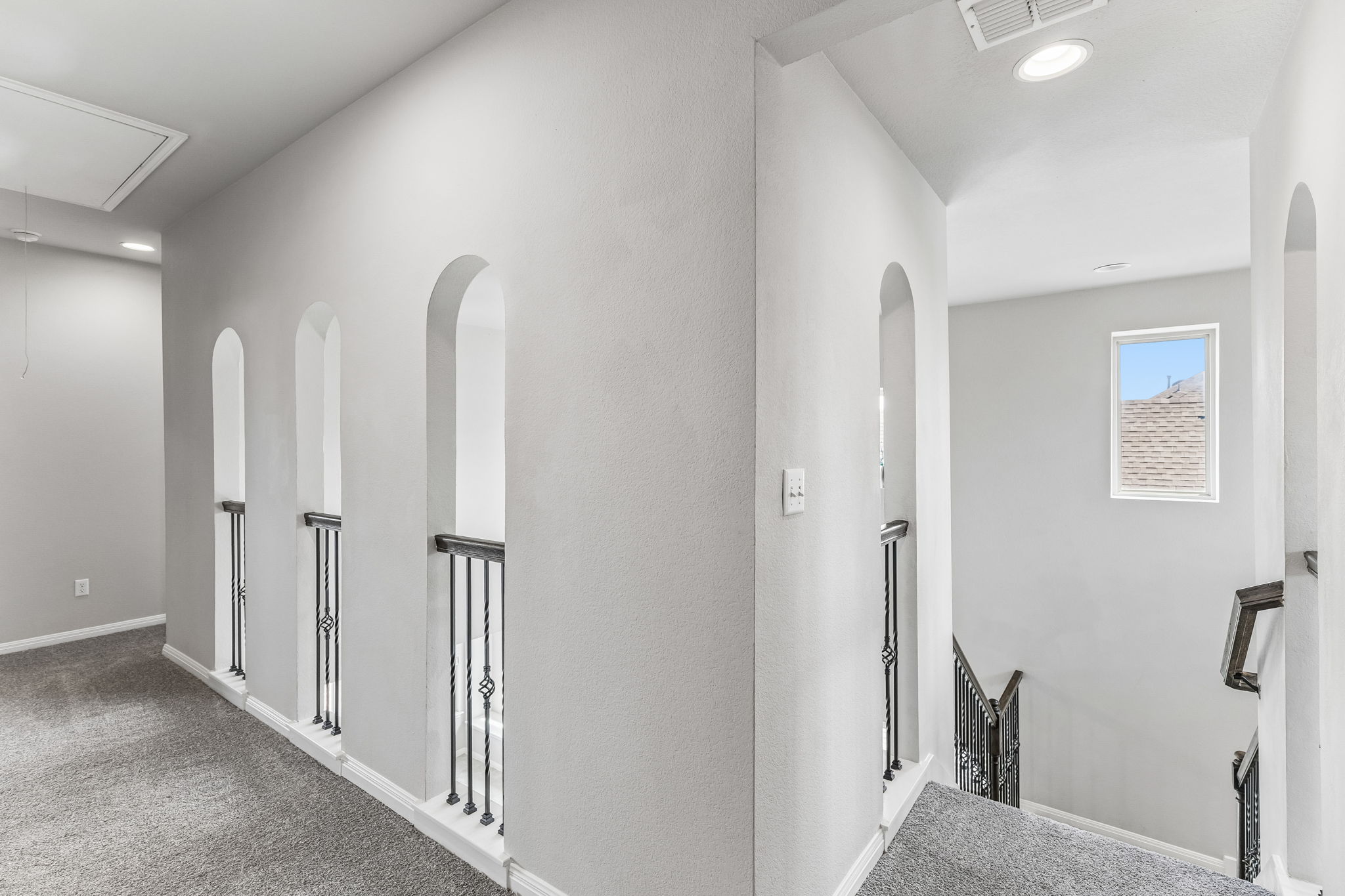 689 Nautical Loop Kyle, TX 78640 - Photo 21 of 34 An airy upper-level landing features decorative arched openings overlooking the staircase.