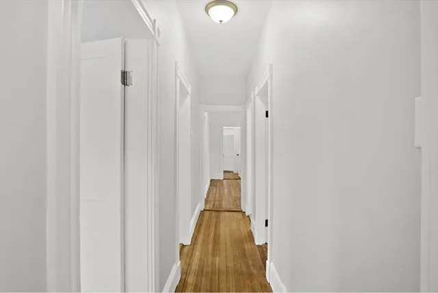 a view of a hallway with wooden floor and windows