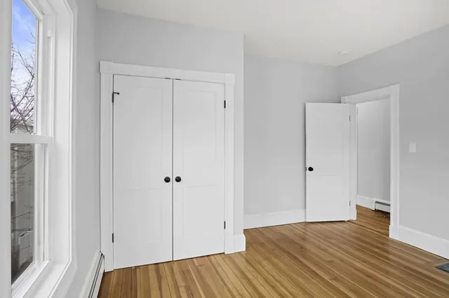 a view of bathroom with a sink wooden floor and closet