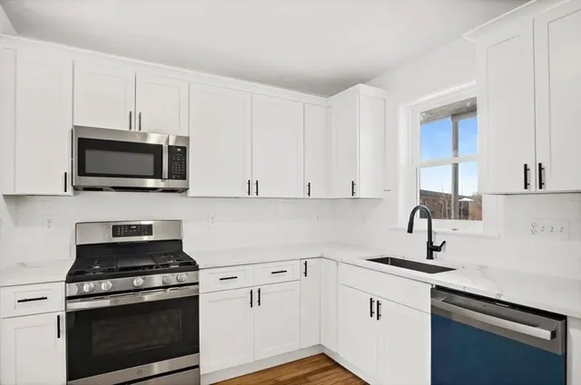 a kitchen with white cabinets and stainless steel appliances