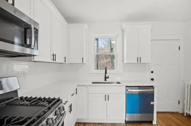 a kitchen with stainless steel appliances granite countertop a sink stove and microwave