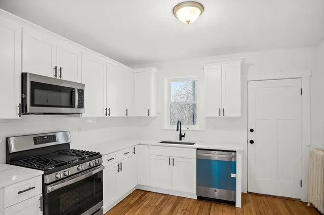 a kitchen with granite countertop white cabinets and appliances