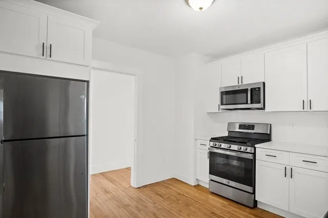 a kitchen with stainless steel appliances a refrigerator stove and microwave