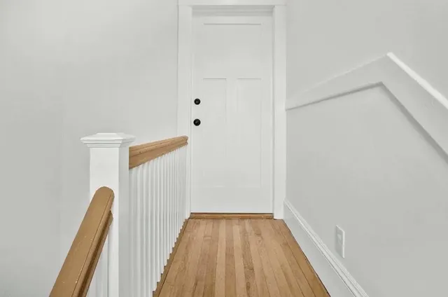 a view of a room with wooden floor and a ceiling fan