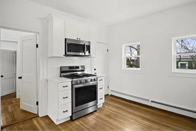 a kitchen with white cabinets and stainless steel appliances