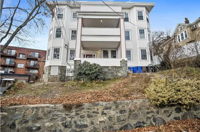 a view of a white house with large windows and a yard