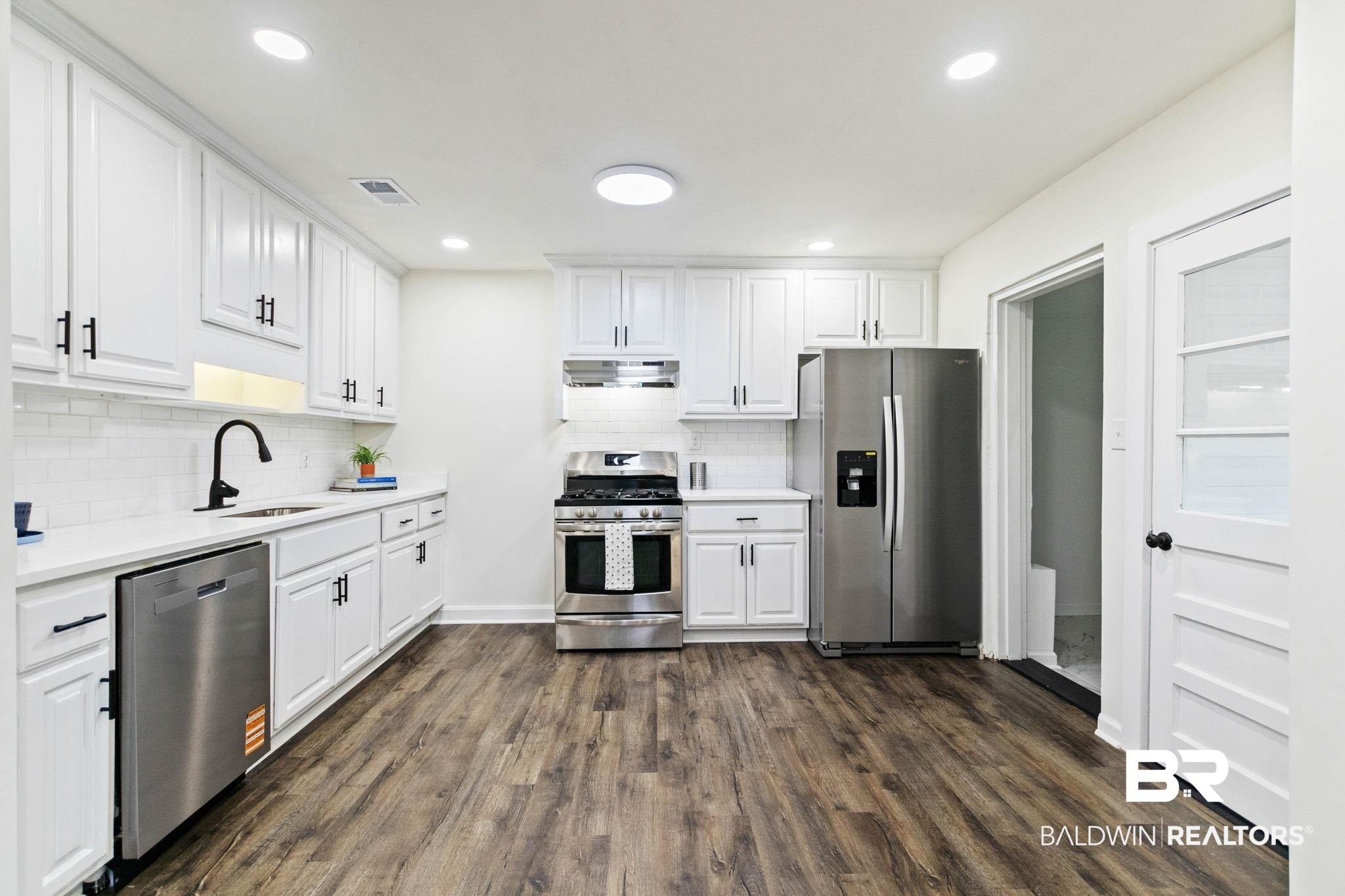 618 Pine Street Saraland, AL 36571 - Photo 16 of 41 Kitchen featuring white cabinetry, appliances with stainless steel finishes, dark wood finished floors, recessed lighting, and backsplash