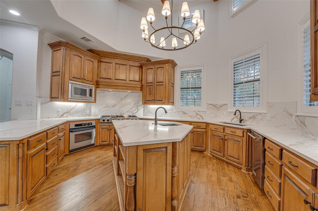 2216 Kings Pass Heath, TX 75032 - Photo 9 of 40 a kitchen with stainless steel appliances granite countertop a sink dishwasher stove and refrigerator with wooden floor