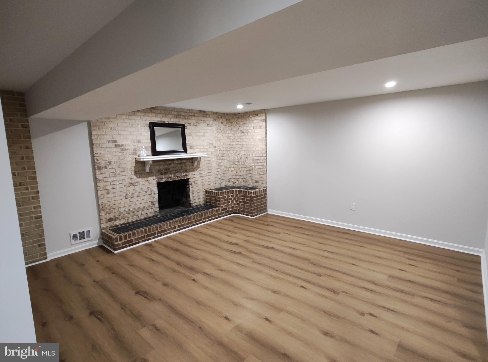 15712 Brandywine Road Dumfries, VA 22025 - Photo 11 of 15 an empty room with wooden floor fireplace and windows