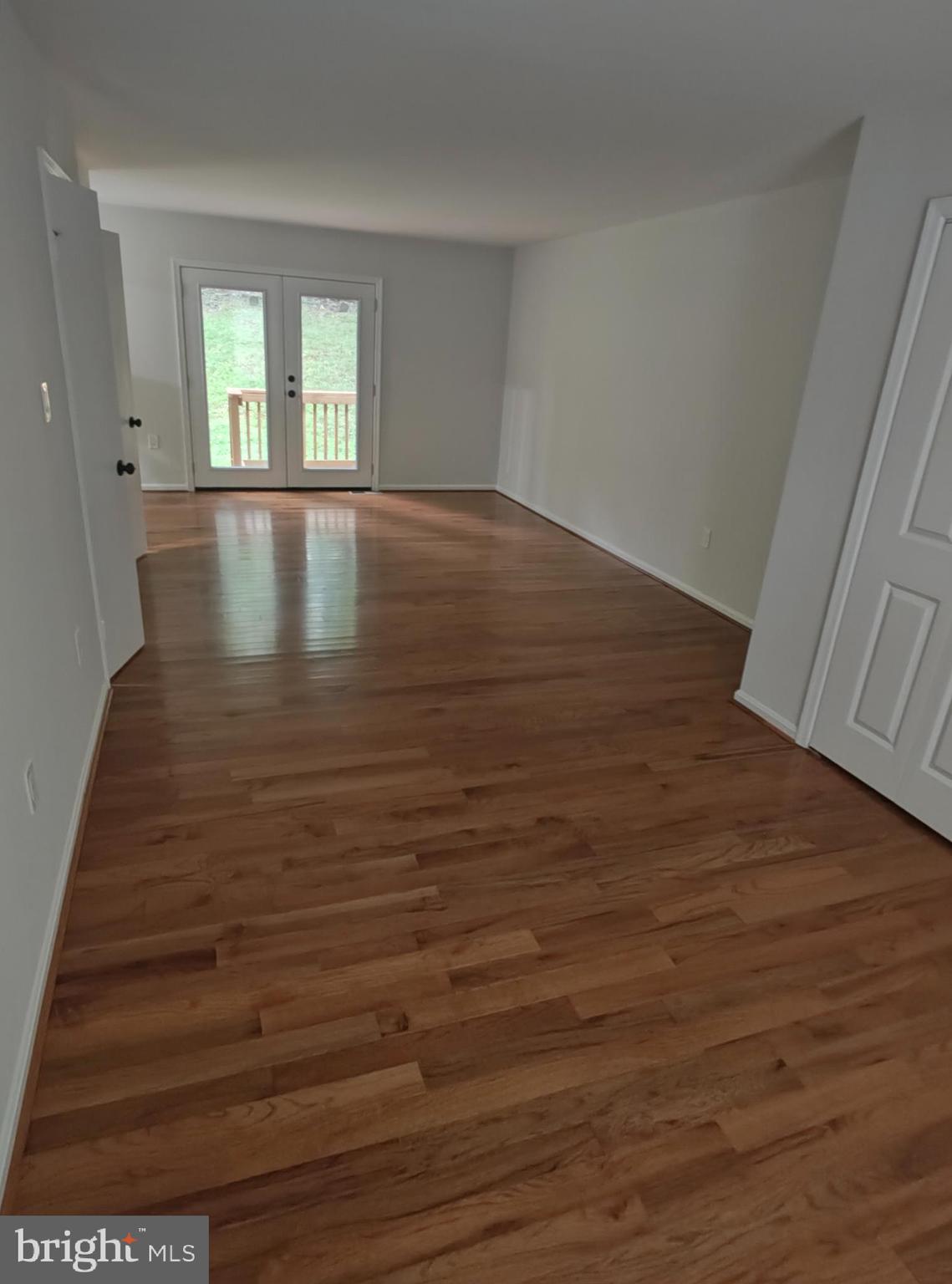 15712 Brandywine Road Dumfries, VA 22025 - Photo 7 of 15 a view of an empty room with wooden floor and a window