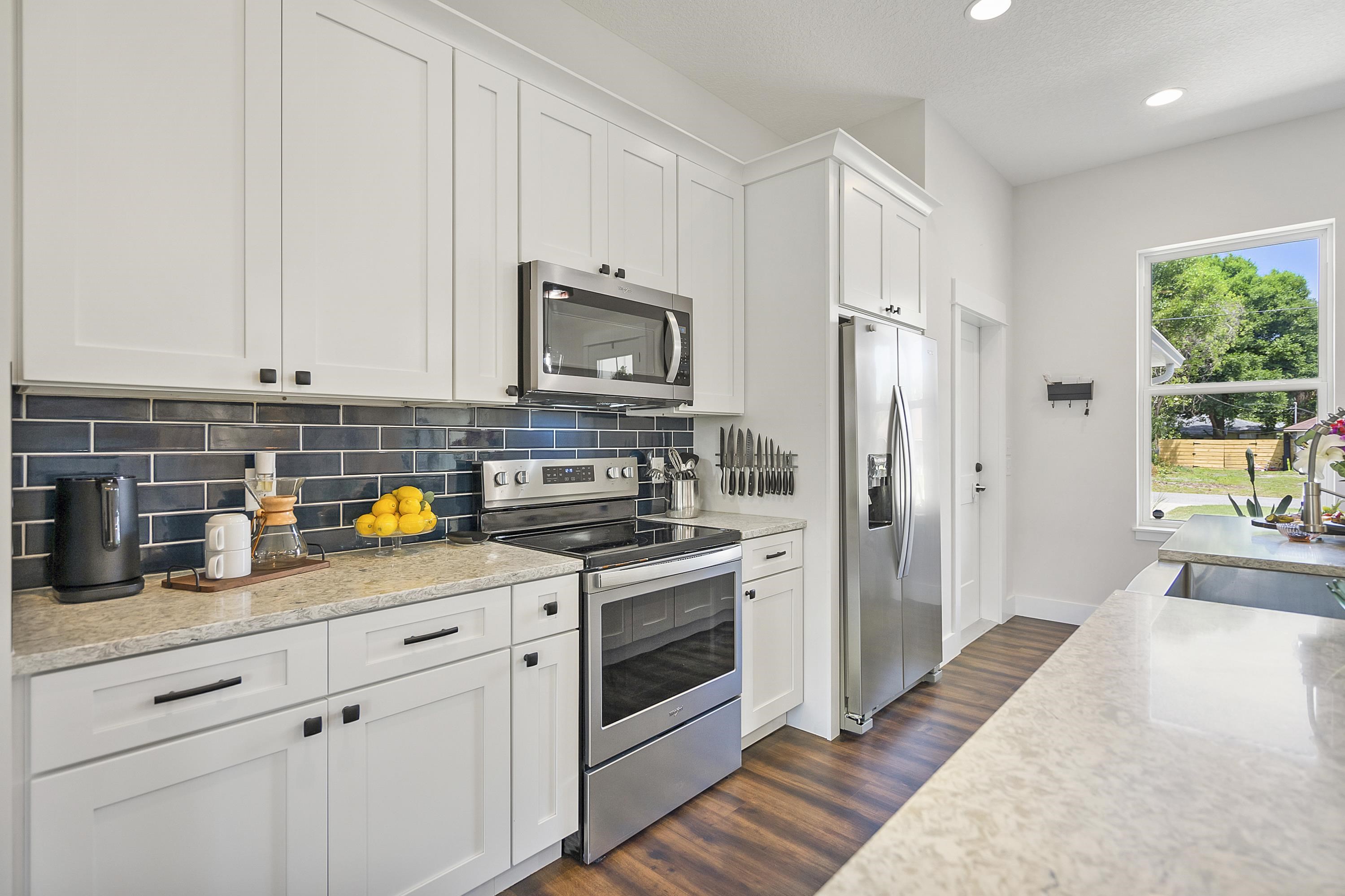 140 Swallow Road St. Augustine, FL 32086 - Photo 9 of 43 a kitchen with stainless steel appliances granite countertop a refrigerator a stove a sink and a white cabinets