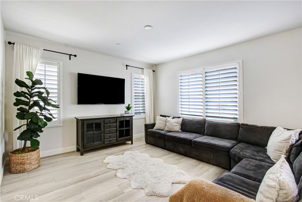 11079 Longfield Lane Eastvale, CA 91752 - Photo 3 of 16 a living room with furniture a flat screen tv and a fireplace