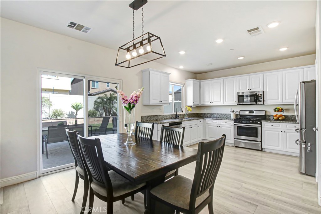 11079 Longfield Lane Eastvale, CA 91752 - Photo 6 of 16 a view of a dining room with furniture wooden floor and chandelier