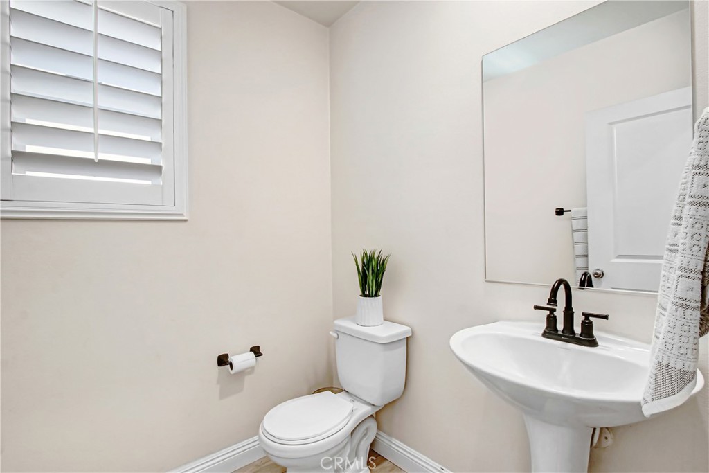 11079 Longfield Lane Eastvale, CA 91752 - Photo 8 of 16 a bathroom with a sink a toilet and mirror