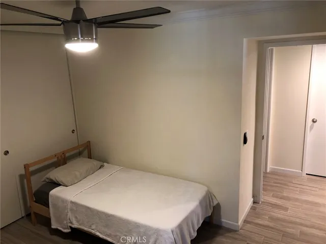 a bedroom with a bed and wooden floor