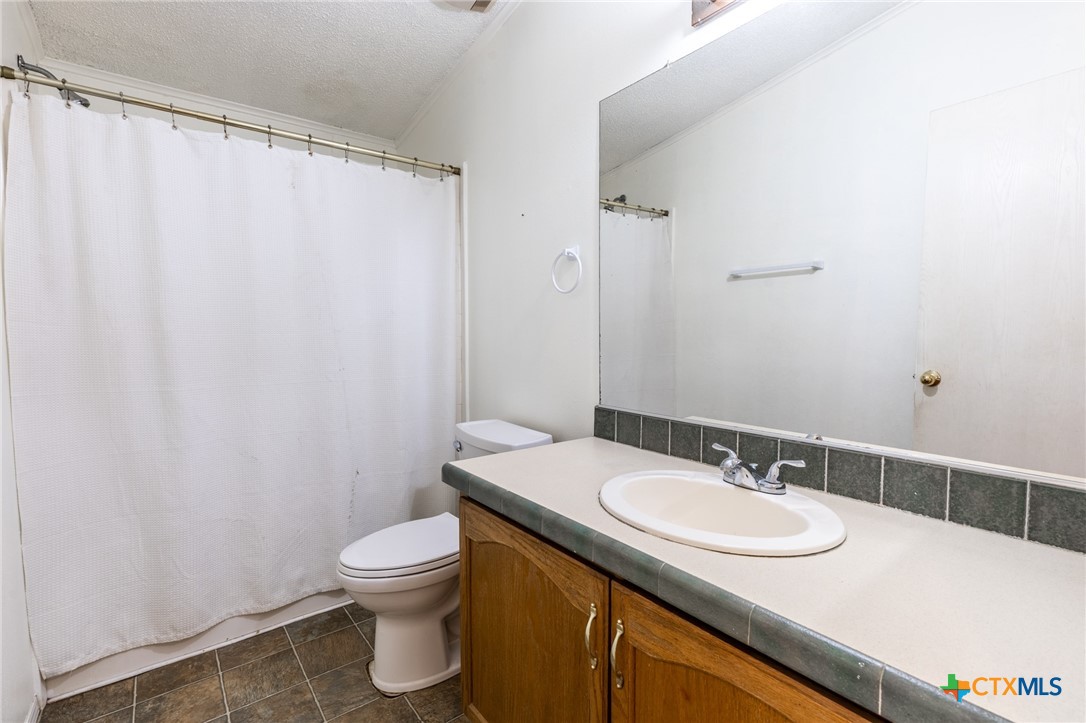 5526 Farm To Market 20 Seguin, TX 78155 - Photo 13 of 18 a bathroom with a granite countertop sink toilet and a mirror