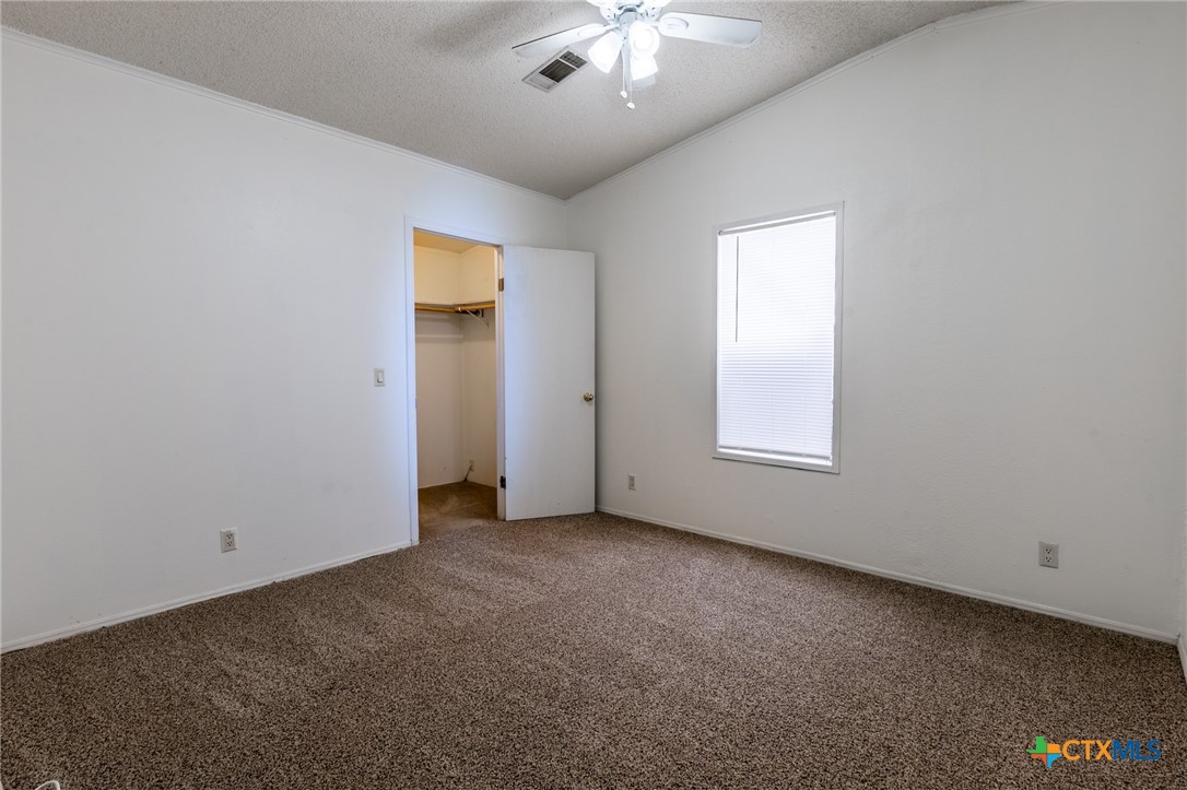5526 Farm To Market 20 Seguin, TX 78155 - Photo 14 of 18 an empty room with a chandelier fan and windows