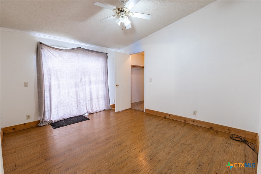 5526 Farm To Market 20 Seguin, TX 78155 - Photo 15 of 18 an empty room with wooden floor chandelier fan and windows