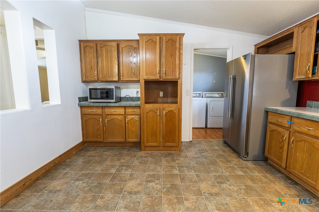 5526 Farm To Market 20 Seguin, TX 78155 - Photo 9 of 18 a kitchen with granite countertop a refrigerator and a stove top oven