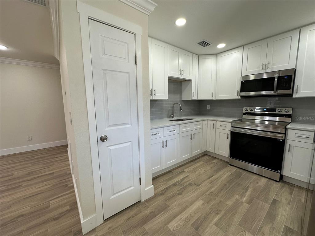 6013 Fortune Place, Unit 6013 Apollo Beach, FL 33572 - Photo 12 of 38 a kitchen with stainless steel appliances a stove top oven a sink and a refrigerator