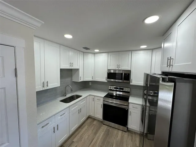 a kitchen with a refrigerator a sink and cabinets