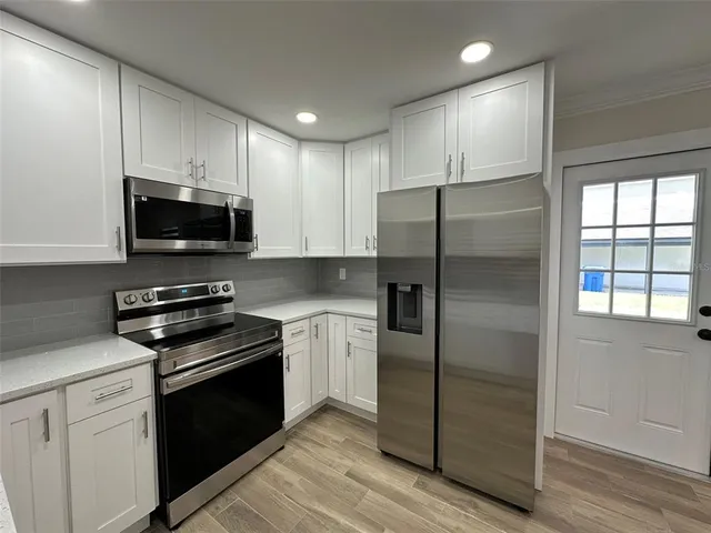 a kitchen with a refrigerator stove and microwave