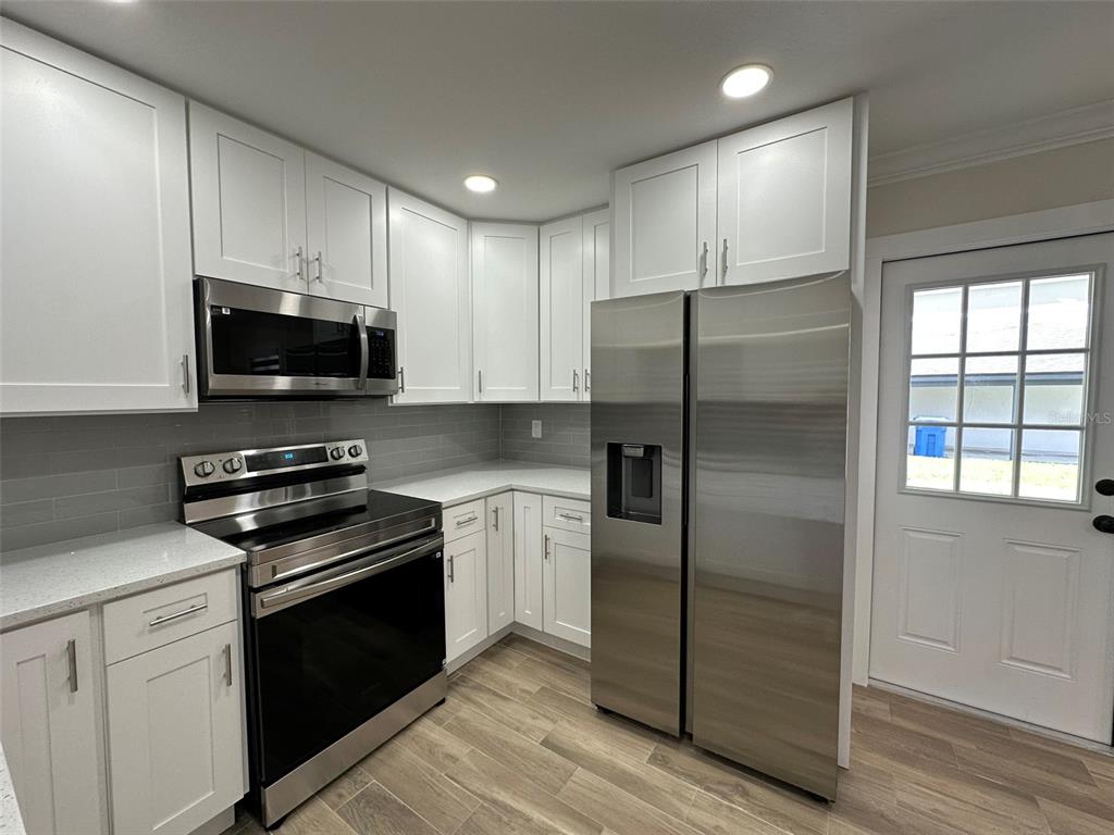 6013 Fortune Place, Unit 6013 Apollo Beach, FL 33572 - Photo 18 of 38 a kitchen with a refrigerator stove and microwave