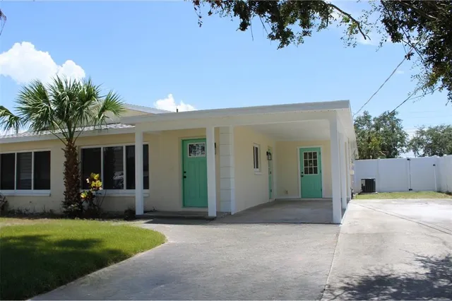 front view of a house with a yard and potted plants