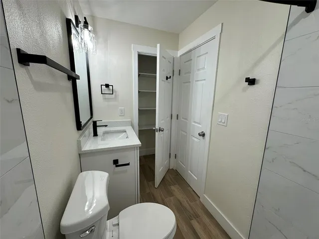 a bathroom with a sink a toilet a mirror and shower